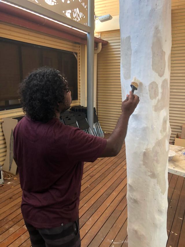 IshmaelMarika painting a log