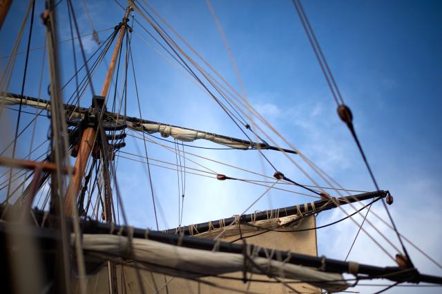 Tall ship masts and sails and a blue sky