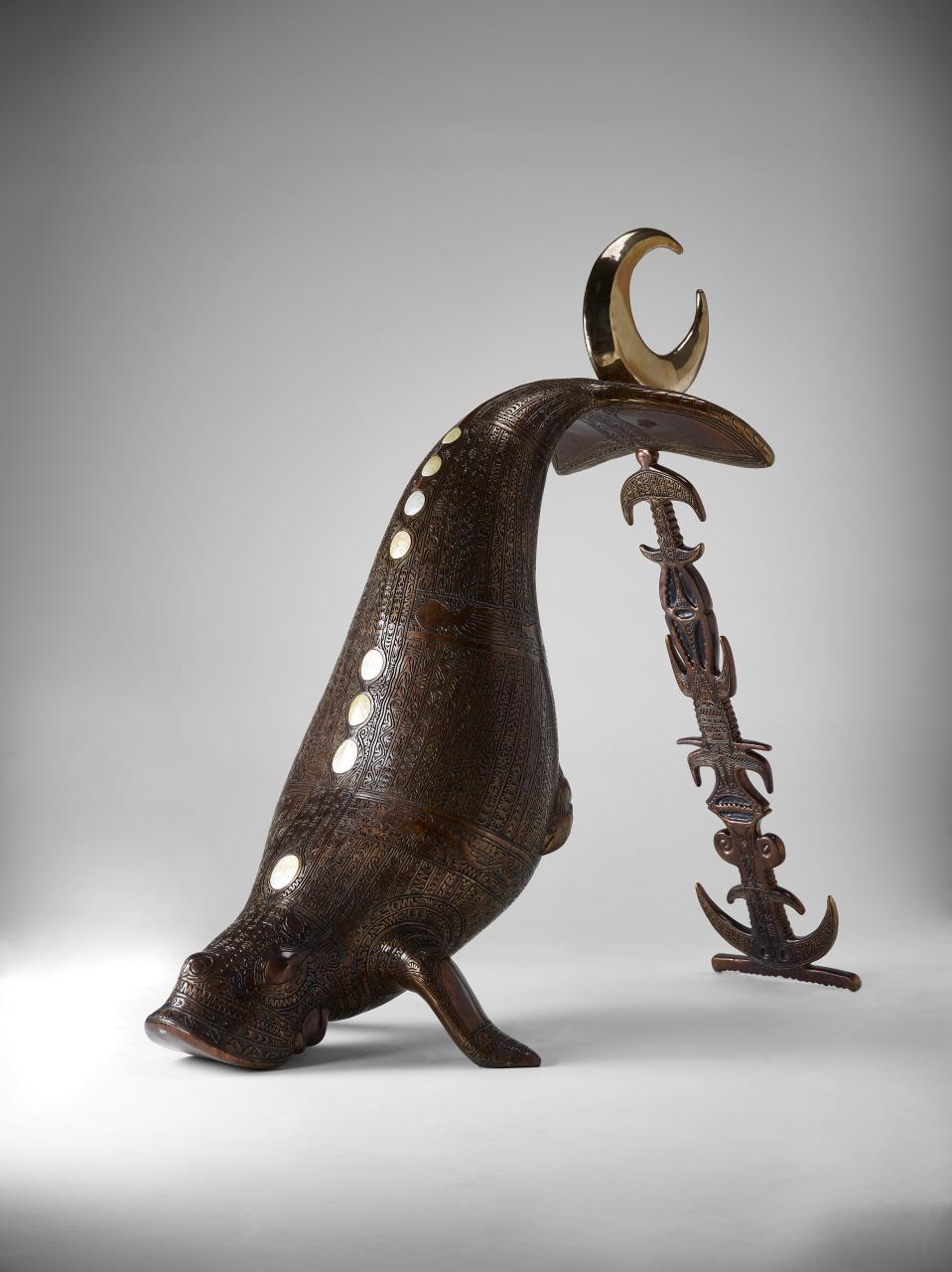 A bronze sculpture in the shape of a Dugong, shown with its tail in the air