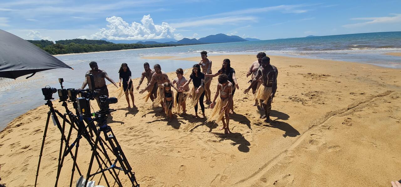 Performers on the beach in front of cameras