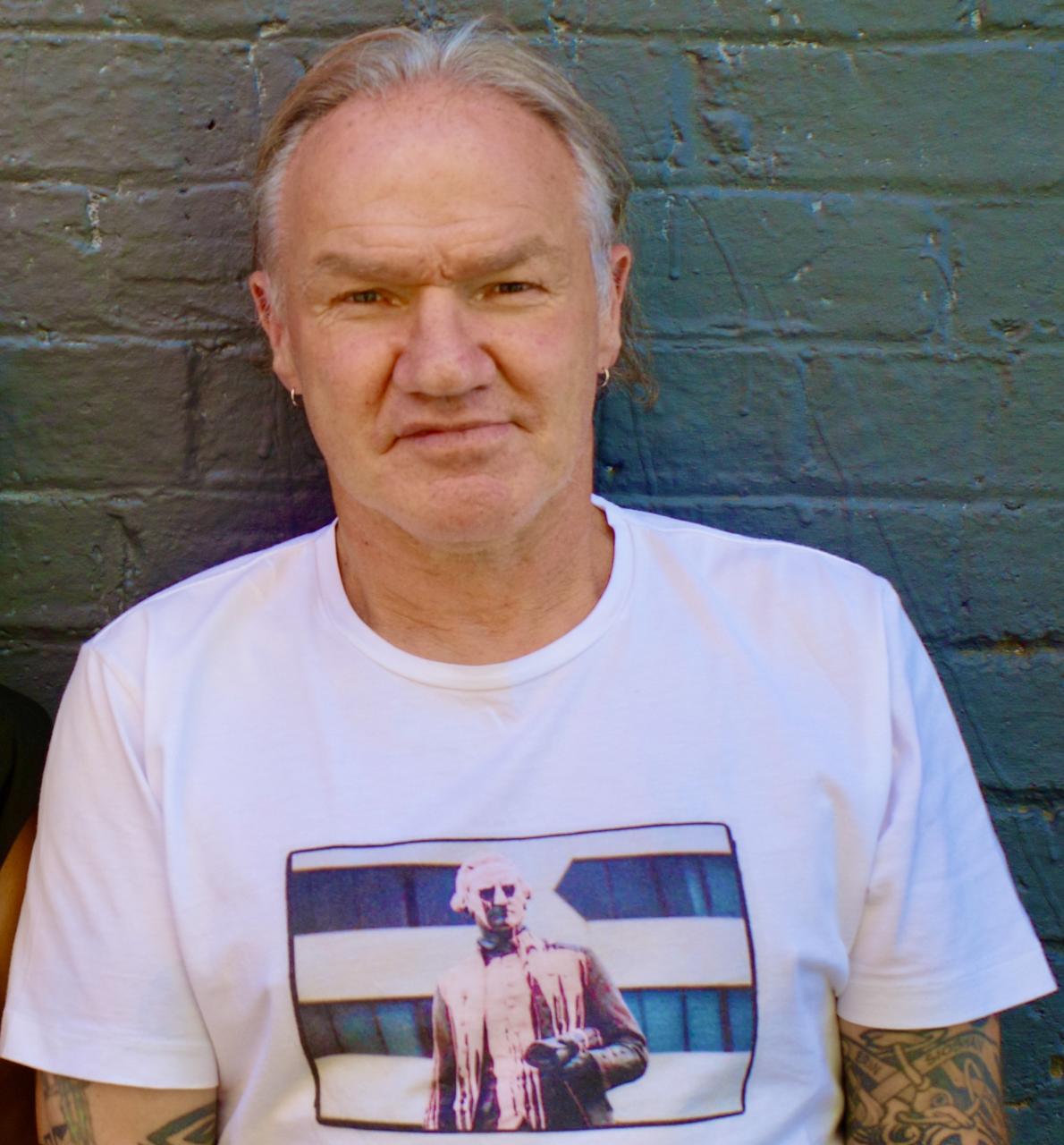 Photograph of author Tony Birch standing against a brick wall